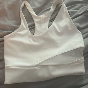 this is a free people tank top that is white with mesh cutouts